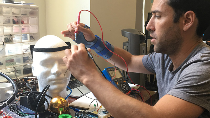 A man solders components on a dummy head