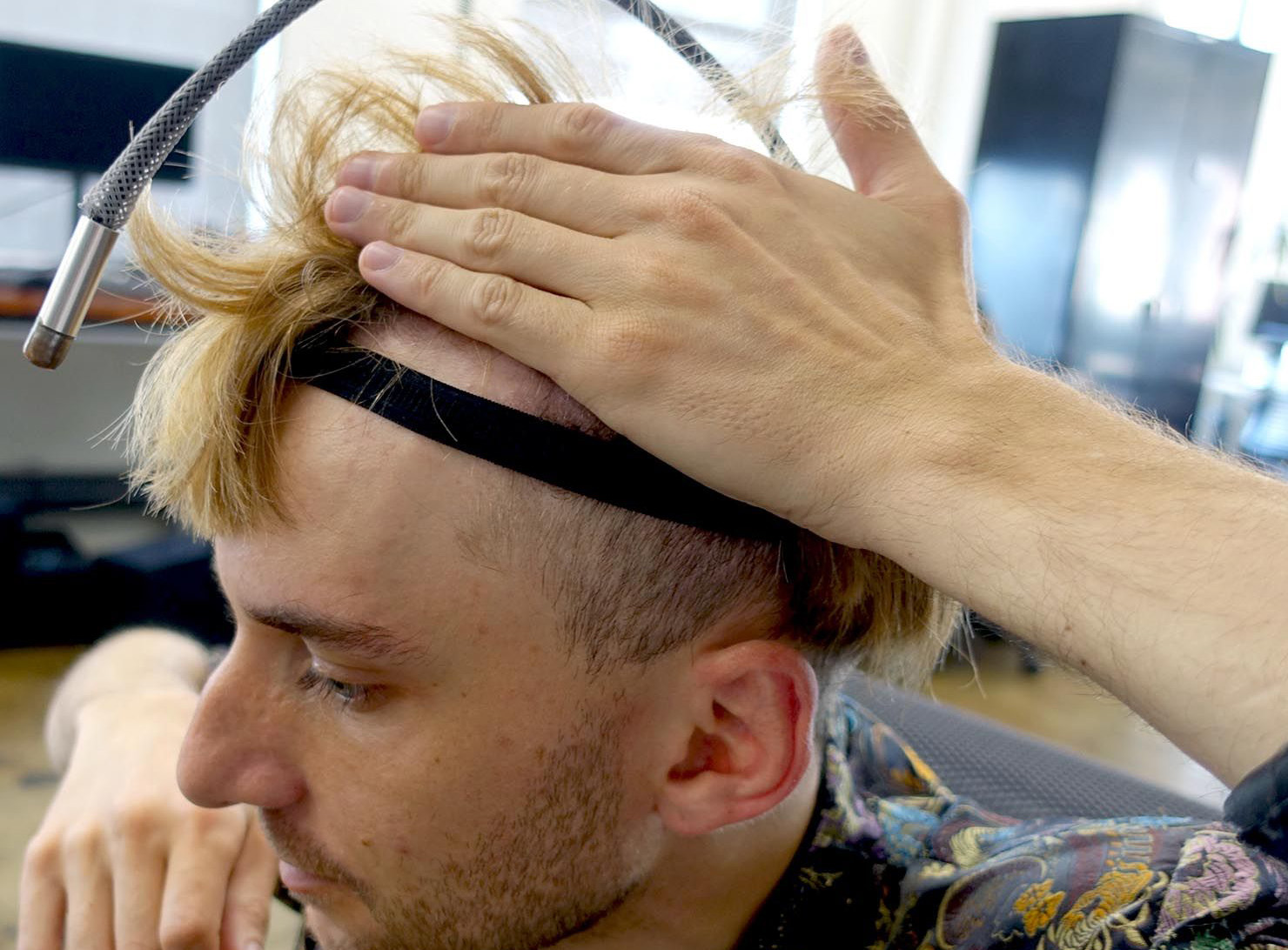 Neil holds up his hair to show a test headband