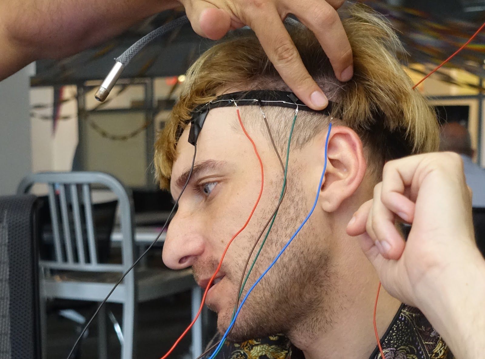 Engineers moving Neil’s headband, which has wires coming out of it