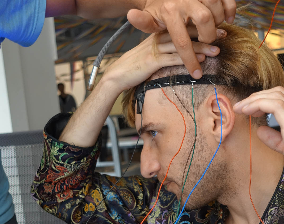 Neil’s head with a headband strap and wires coming from it